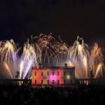 Fans of roman candles behind Queens House in Greenwich at a professional firework display