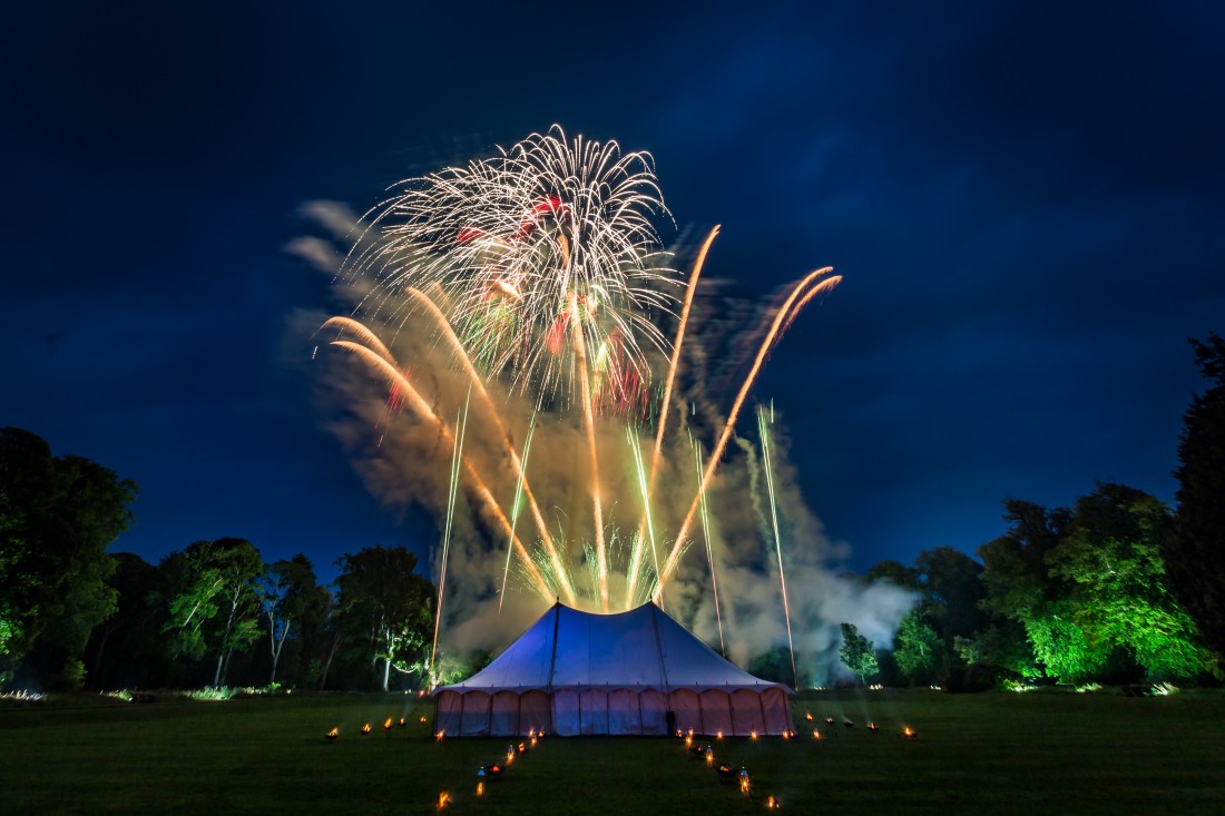 Green shells bursting over a marquee in Scotland for a wedding fireworks display