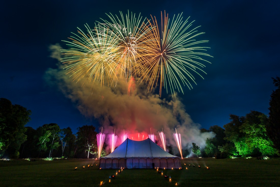 Green shells bursting over a marquee in Scotland for a wedding fireworks display