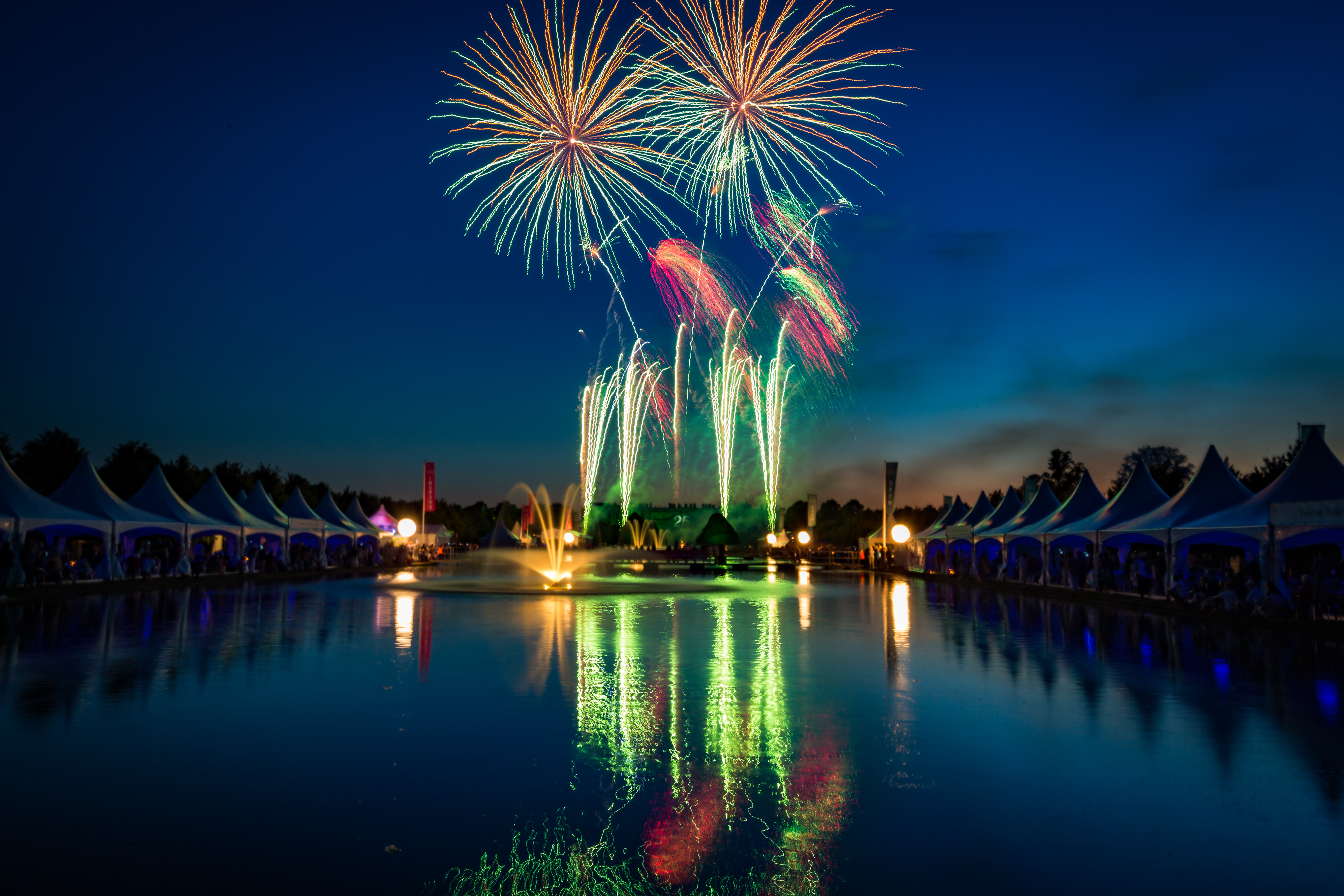 Beautiful reflections in the long water of the fireworks display at Hampton Court Palace for the RHS Hampton Court Palace Flower Show