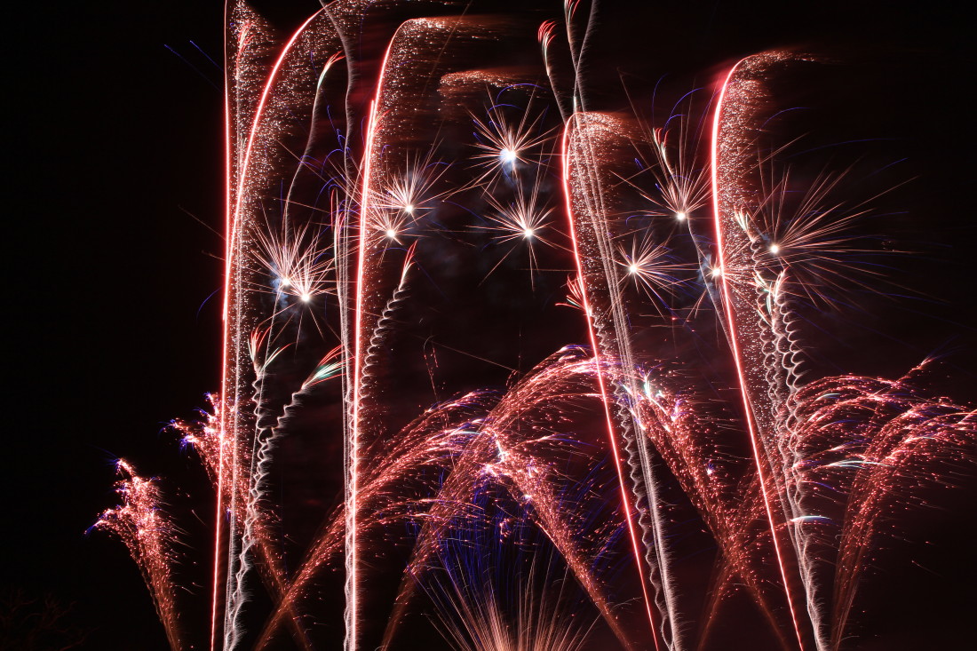 Red professional fireworks crossing over each other