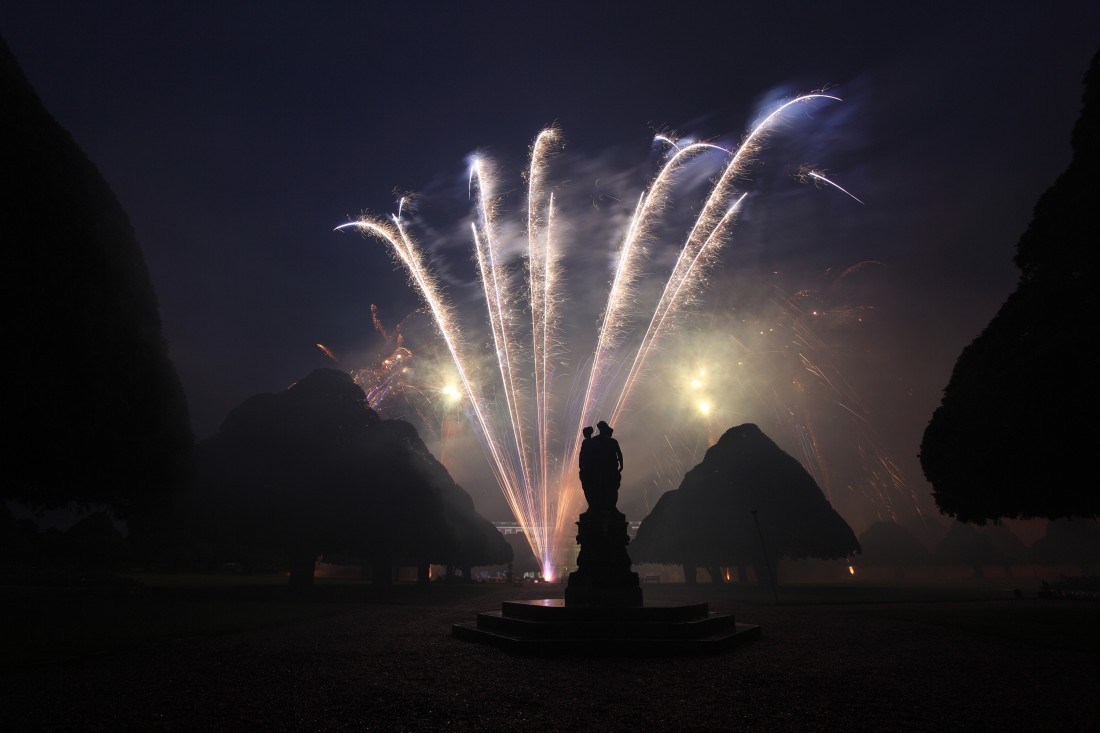 Triangular trees and a statue surrounded by fireworks at Hampton Court Palace