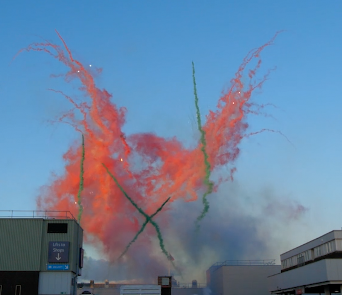 Bright red and green smoke trails for a daylight fireworks display in Middlesbrough